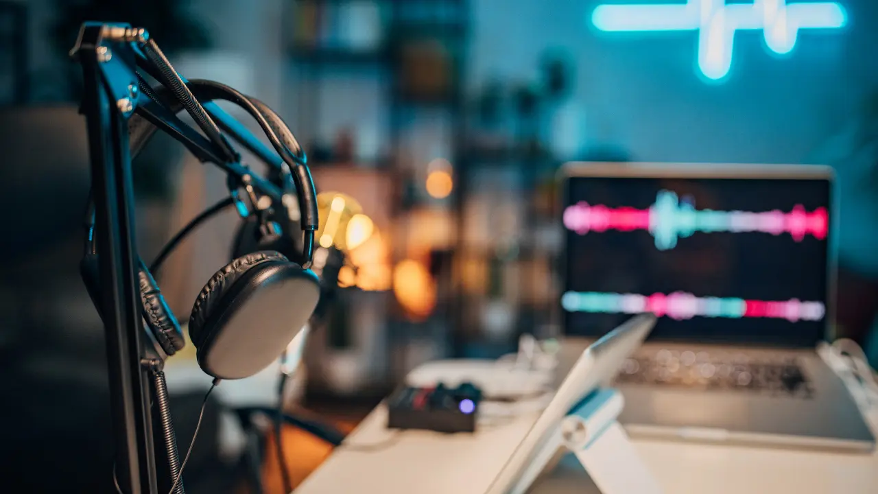 Podcast production desk with headphones and waveform